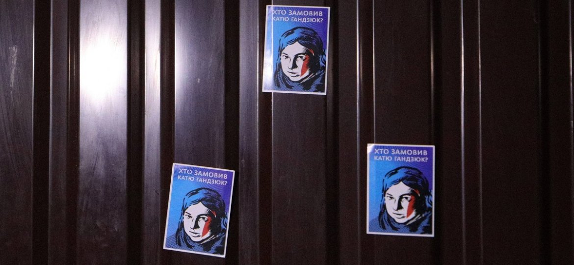 Stickers featuring Kateryna Handziuk are glued to a corrugated iron fence outside the house of Inter