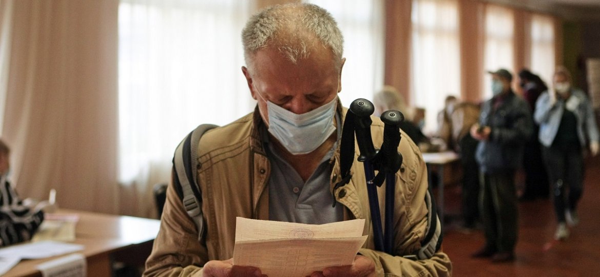 KYIV, UKRAINE - OCTOBER 25, 2020 - A man studies a ballot at a polling station during voting in the 2020 Ukrainian local
